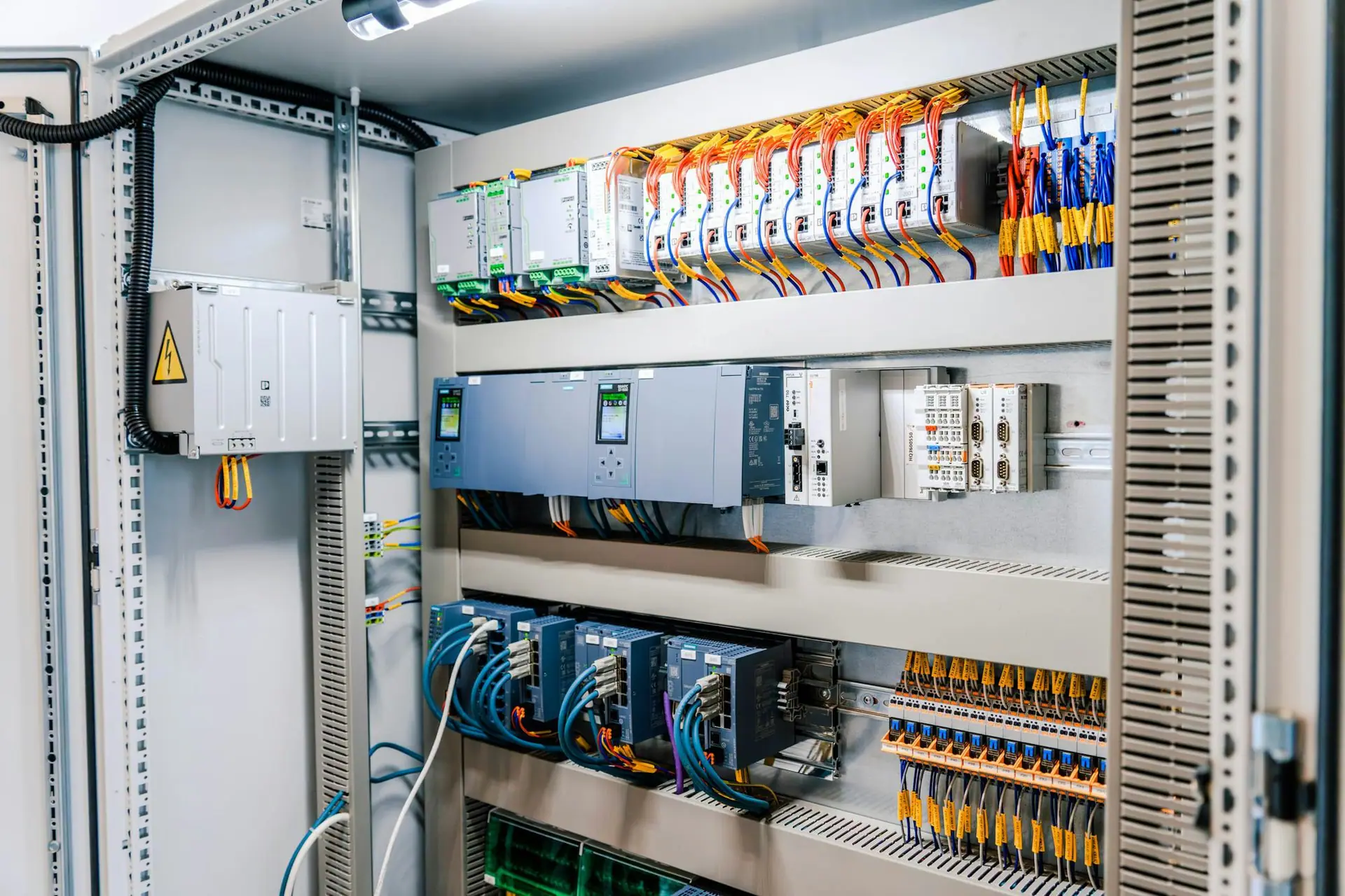 PLC ve sürücü modülleri içeren endüstriyel kontrol panosu